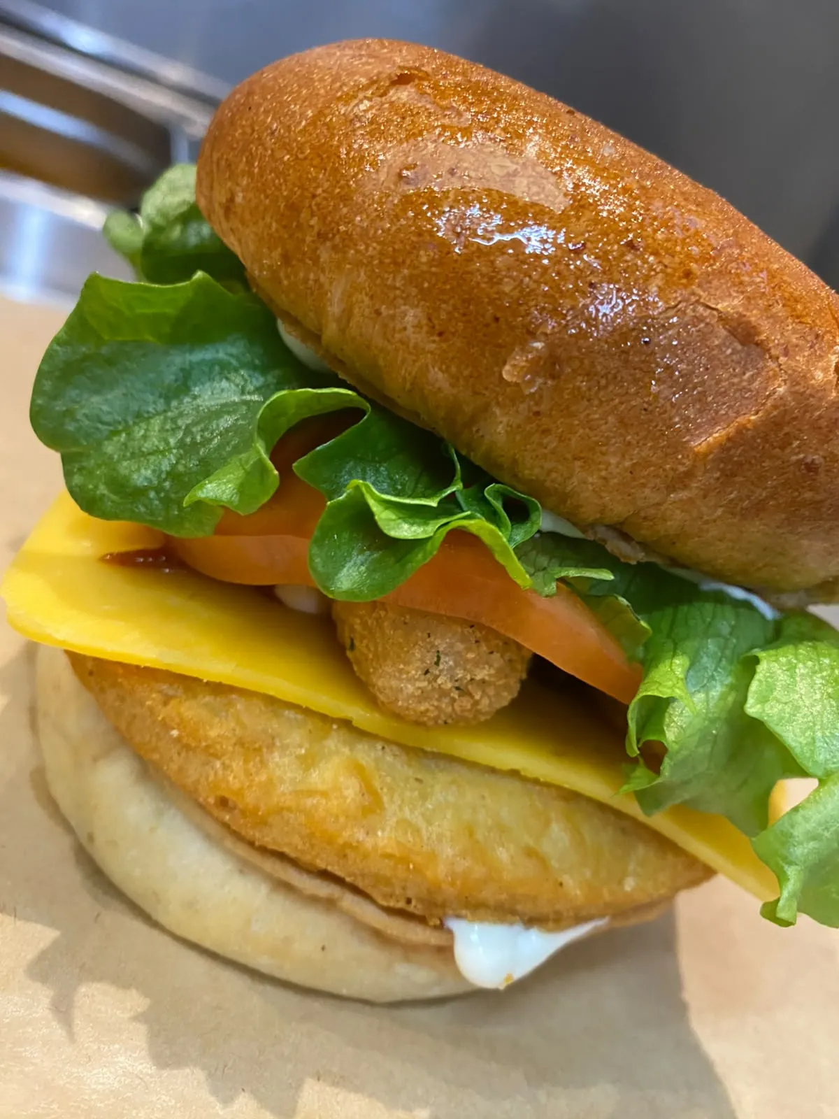 Sprødstegt kyllingeburger med cheddar, tomat, salat og hvidløgscreme